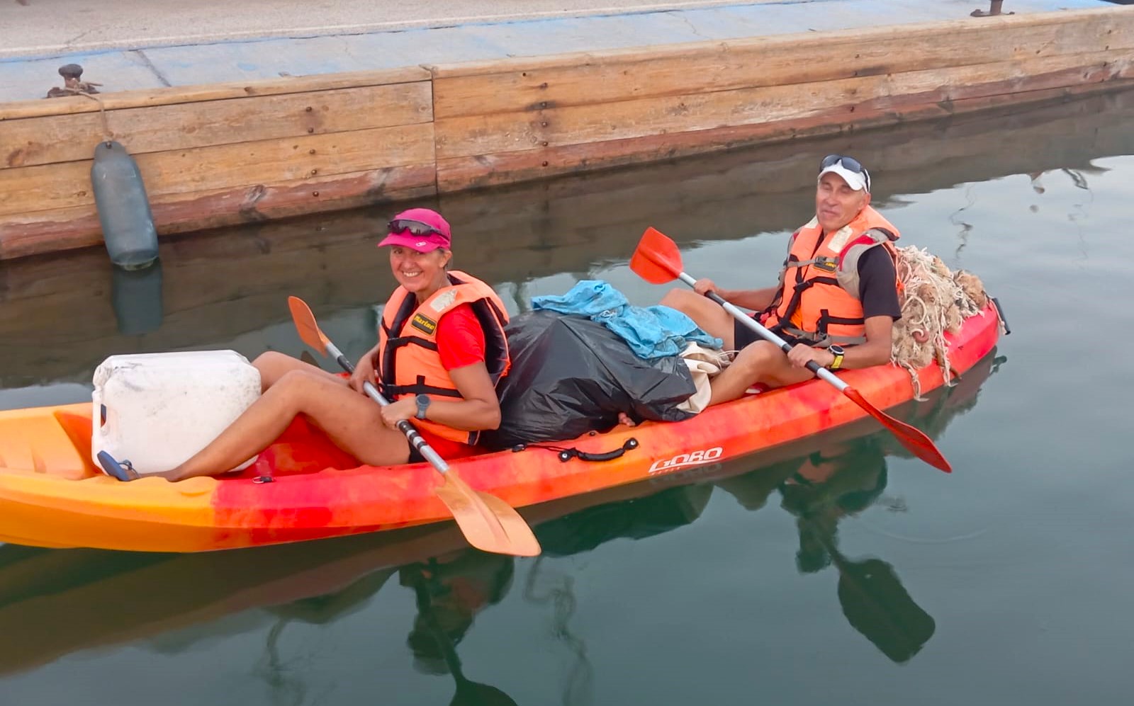 Una pareja de turistas aprovecha sus vacaciones en Águilas para recoger los residuos de plástico que encuentran en sus travesías en kayak